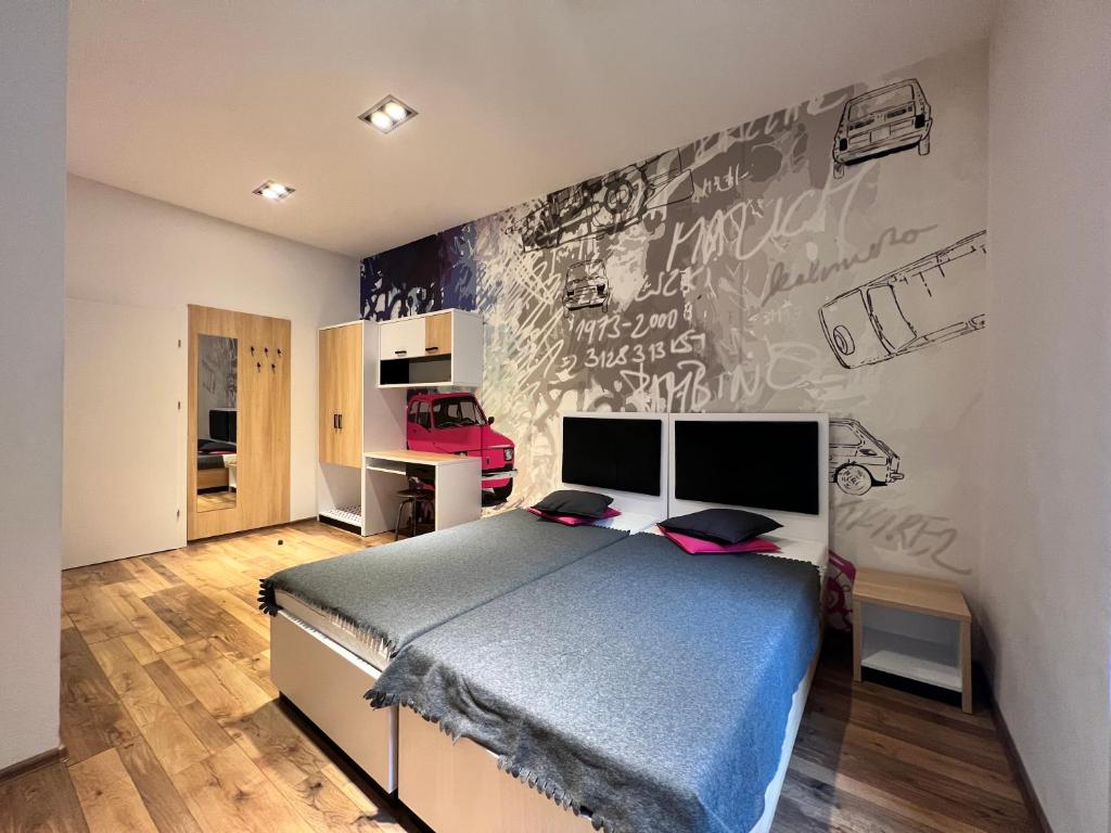 a bedroom with a bed and a wall with graffiti at Mariacka 13 Wygodne Spanie P6 Centrum in Katowice