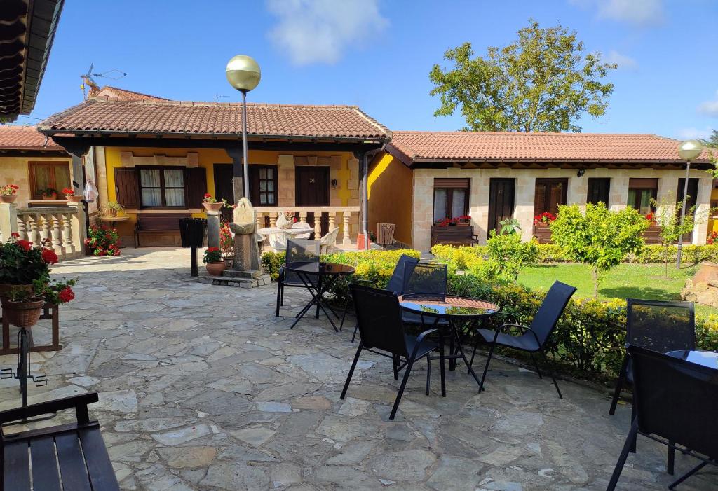 une terrasse avec des tables et des chaises en face d'une maison dans l'établissement Posada de Ongayo, à Suances