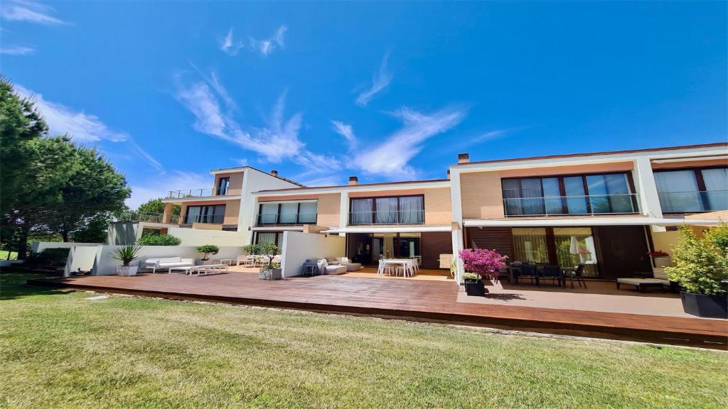 a large house with a large backyard with a deck at Vila Mitri, Monte laguna-CleverDetails, 5 bedroom villa, sleeps 8 adults 2 children in Vilamoura