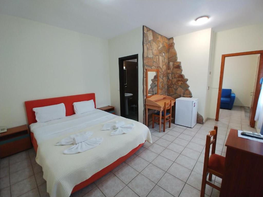 a bedroom with a large bed and a table and chairs at Porto Vistonis in Lágos