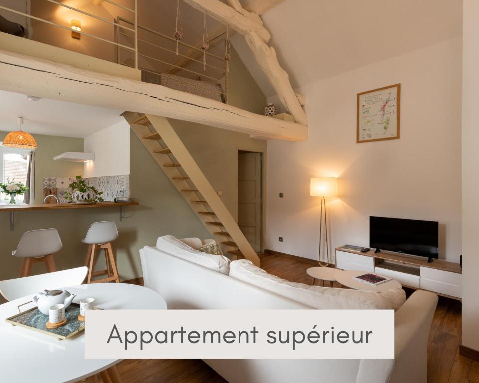 a loft apartment with a loft bed and a living room at M comme Meursault in Meursault