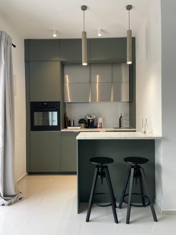 a kitchen with a green counter and stools in it at Studio D2 in Biograd na Moru