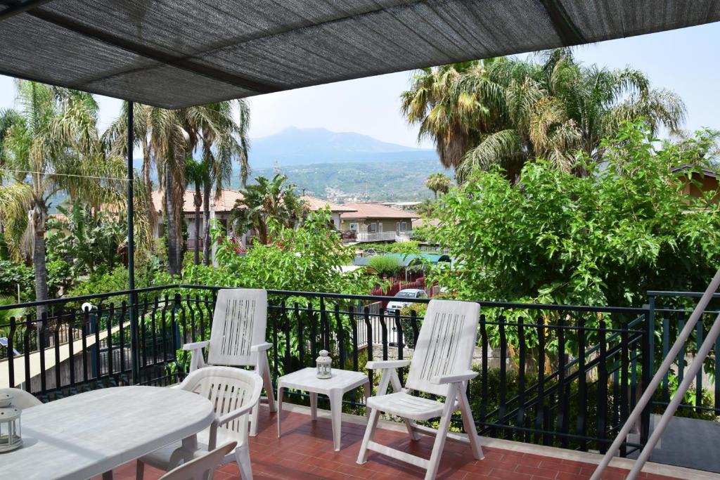 three white chairs and a table on a balcony at Blue Coast Sicily in Fondachello
