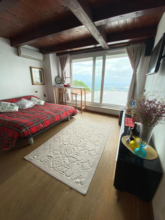 a bedroom with a bed and a large window at San Marino Skyline - Dante in Valdragone