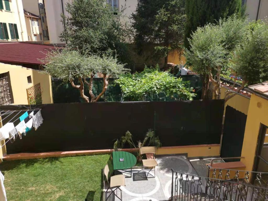 a backyard with a black fence and trees at Affitta camere Mimi family in Florence