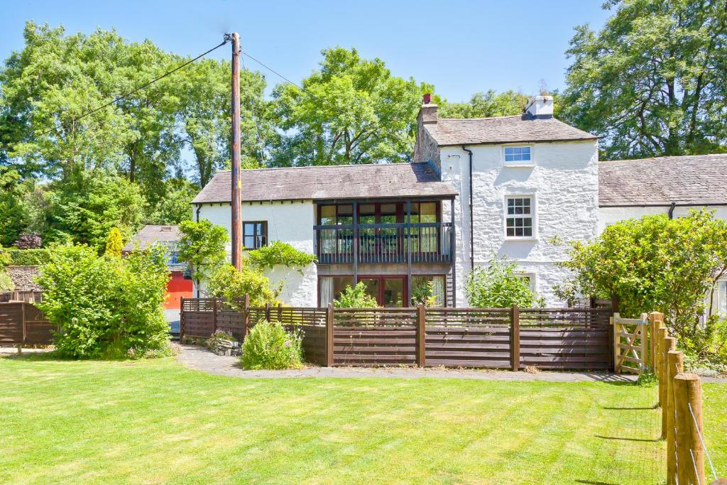 a house with a fence in front of a yard at Sawmill Cottage, Coniston Water in Coniston