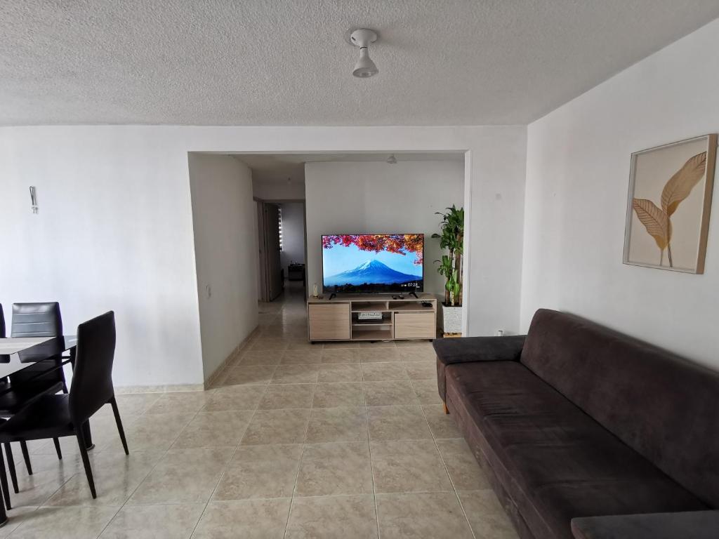 a living room with a couch and a flat screen tv at Mi hogar - Apartamento familiar en Bucaramanga in Bucaramanga