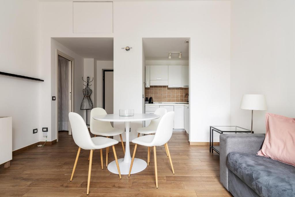 sala de estar con mesa, sillas y sofá en Sabotino apartment, en Milán
