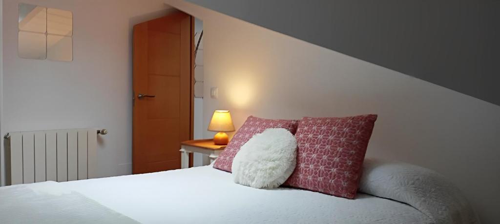 a bedroom with a bed with a pillow and a lamp at Atico con encanto en el mismo centro de la ciudad in Santander