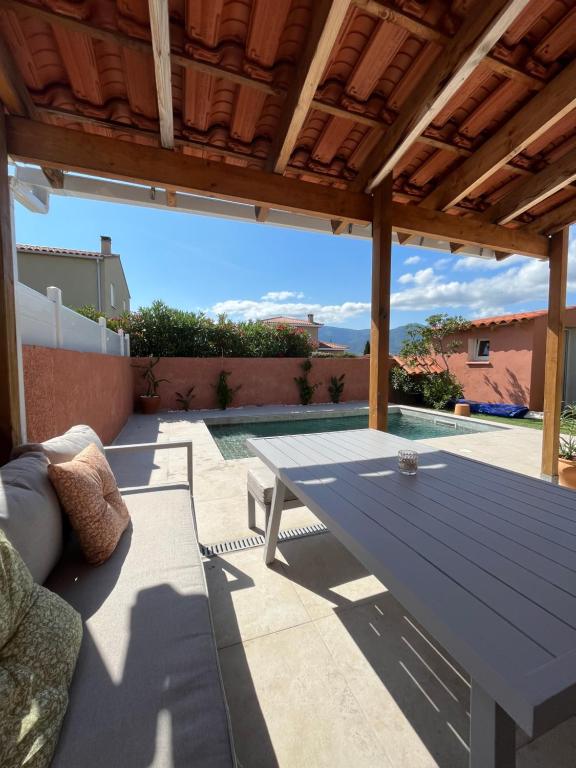 - une table de pique-nique sur la terrasse d'une maison dans l'établissement Villa piscine confort cosy, à Brouilla