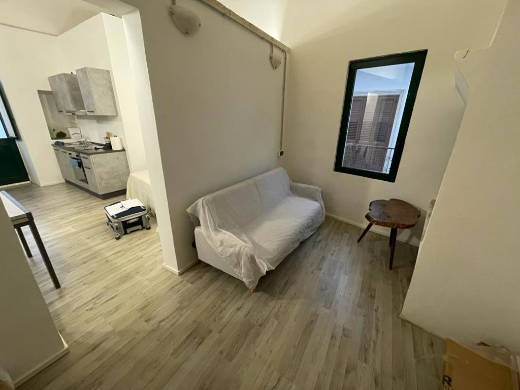 ein Wohnzimmer mit einem weißen Sofa und einem Fenster in der Unterkunft Salento Sunny Flat in Aradeo