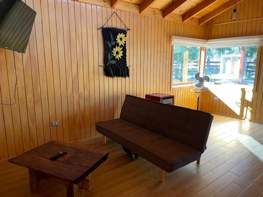 uma sala de estar com um sofá e uma mesa em cabañas anvi pucon em Pucón