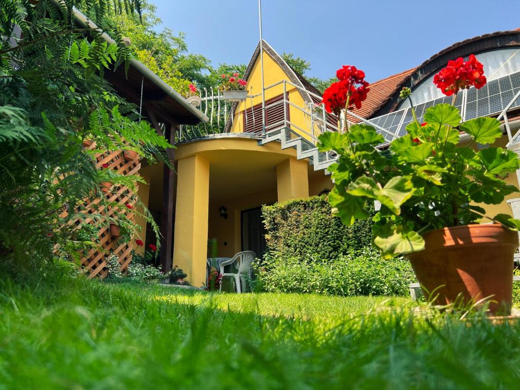una casa amarilla con balcón y una planta en el patio en Óvár 12 Vendégház, en Tokaj