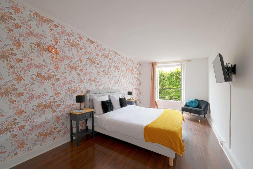 a bedroom with a bed with floral wallpaper at Sublime appartement -Versailles in Versailles