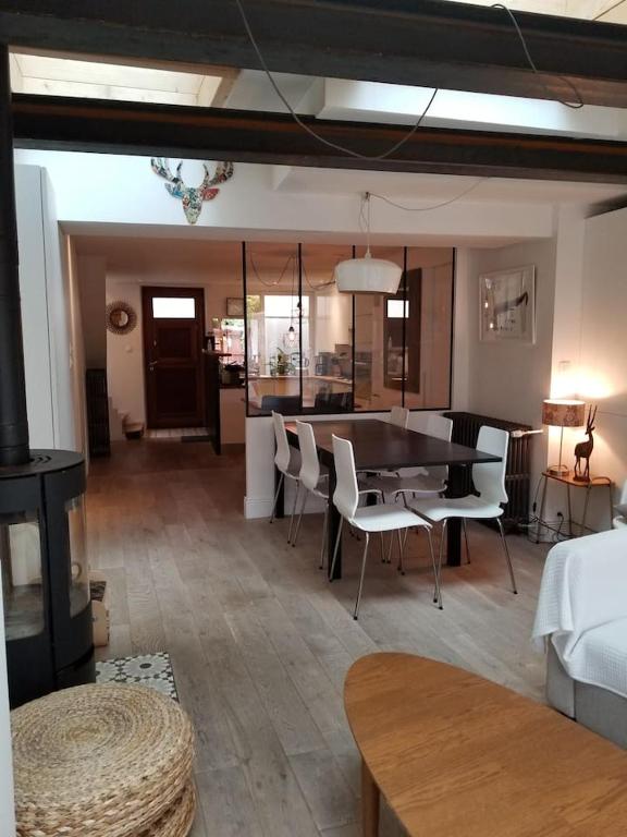 a dining room and living room with a table and chairs at Maison hypercentre calme, terrasse, garage, poêle in Clermont-Ferrand