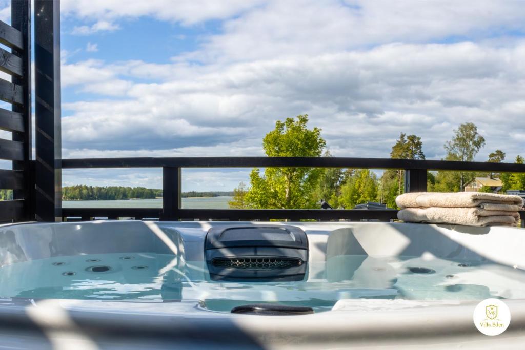 een hot tub op een balkon met uitzicht op het water bij Villa Eden - Design-Sea-Pool-Sauna-Services in Kemionsaari