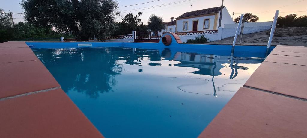 uma piscina com água azul em frente a uma casa em Casas da Balsa em Casal da Igreja