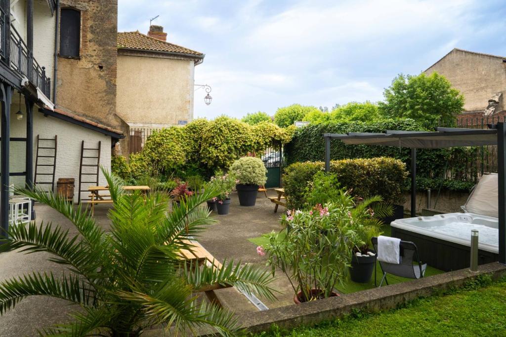 un jardín con bañera en un patio en Hôtel Le Loft, en Trie sur Baise