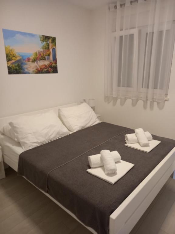 sypialnia z łóżkiem i dwoma ręcznikami na nim w obiekcie Apartmani Manuela w Okrugu Gornjim