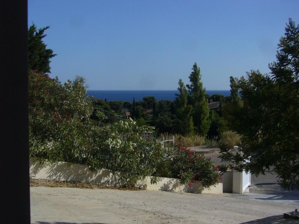 a view of the ocean from a hill with trees and flowers at Chez Pascal grand T2 de 55m2 indépendant dans villa in Sausset-les-Pins