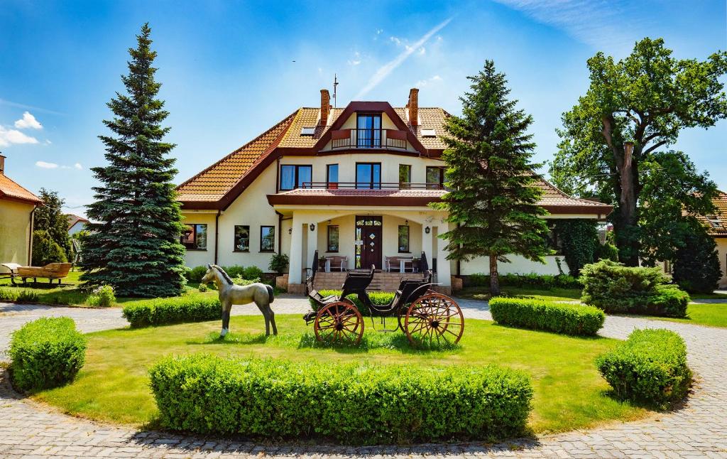 a horse drawn carriage in front of a house at Ranczo Mustafa in Bobolin