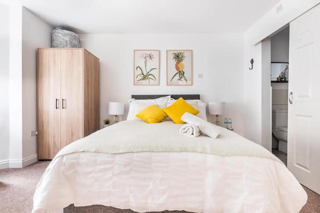 考文垂的住宿－Northumberland Boutique Guest House #1，白色卧室配有一张带黄色枕头的大床