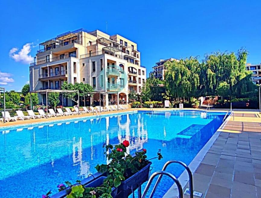 une grande piscine en face d'un bâtiment dans l'établissement Sorrento Sole Mare - Apartments by the beach, à Sveti Vlas