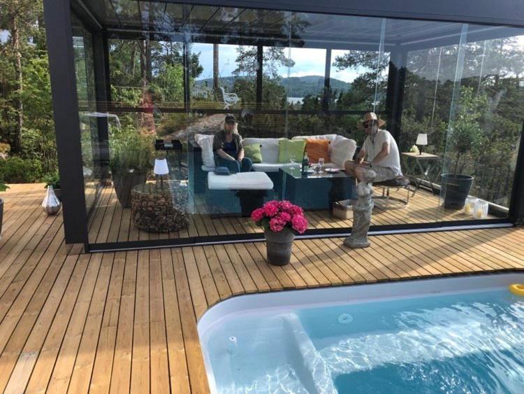 a man standing on a deck next to a swimming pool at Leilighet i Sørlandshus i Son - Sjøutsikt - Nær Son Spa in Son