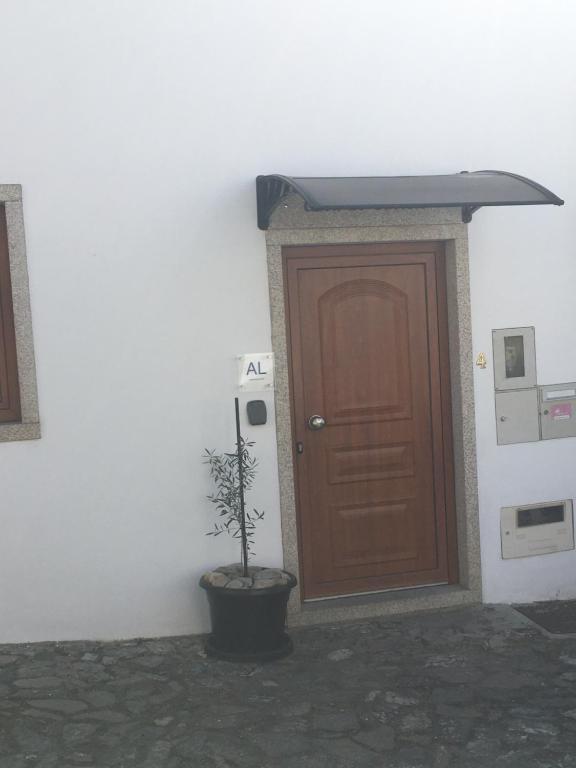 een houten deur met een potplant ervoor bij Casa do Castelo I in Bragança