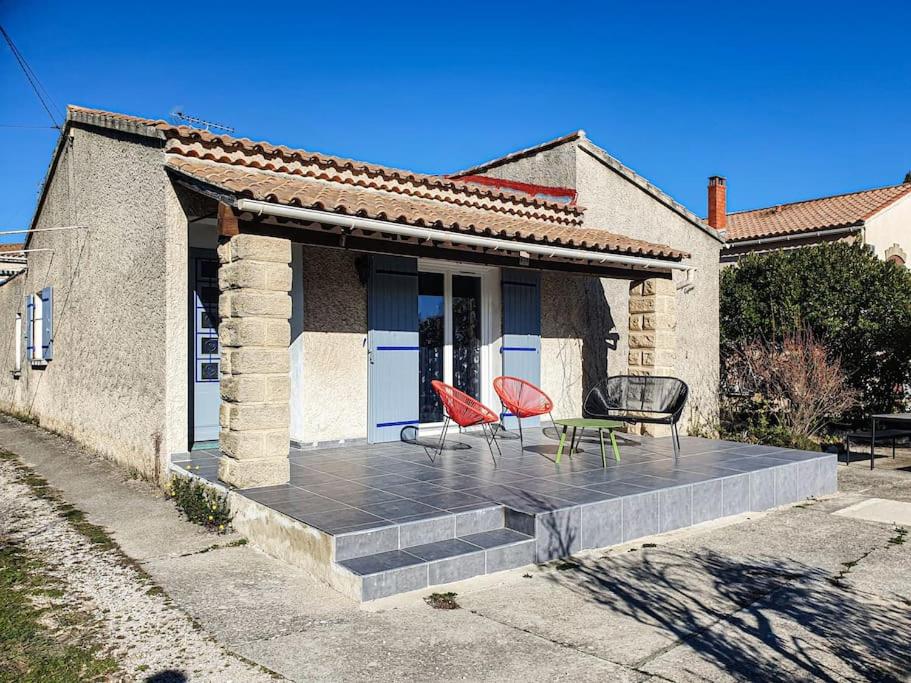 dos sillas y una mesa en una terraza frente a una casa en Villa Mon Caprice, en Roquemaure