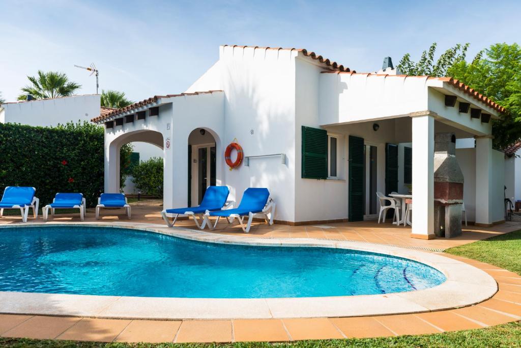 a villa with a swimming pool in front of a house at Apartchalet villas Elvira. Villa F in Son Carrio