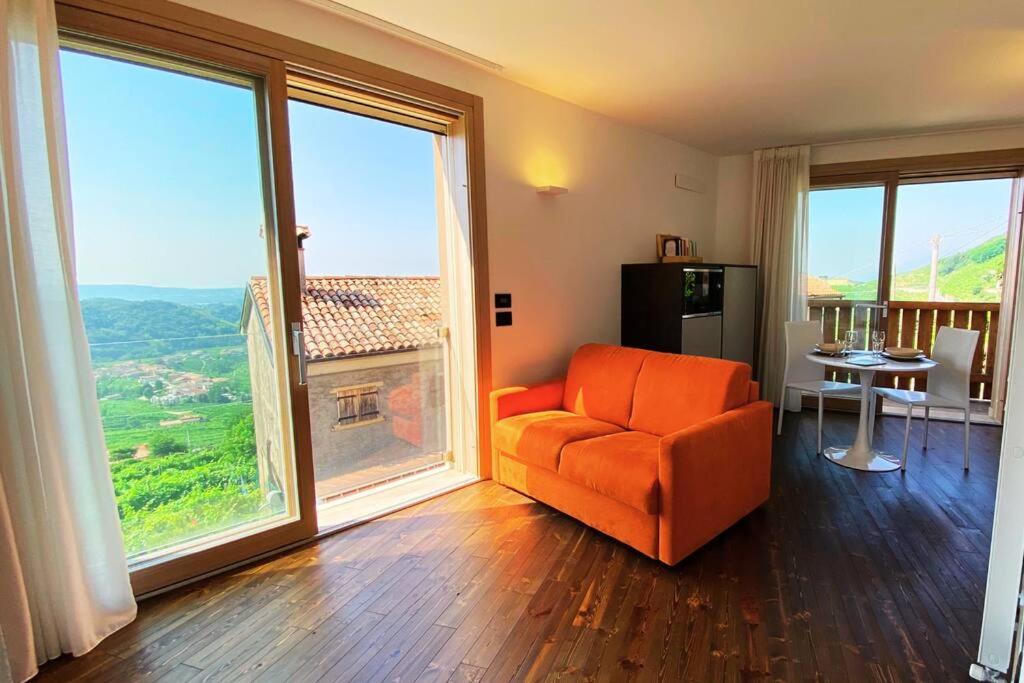 sala de estar con silla naranja y ventanas grandes en ValdoCaban: Oasis among the Vines, en Santo Stefano