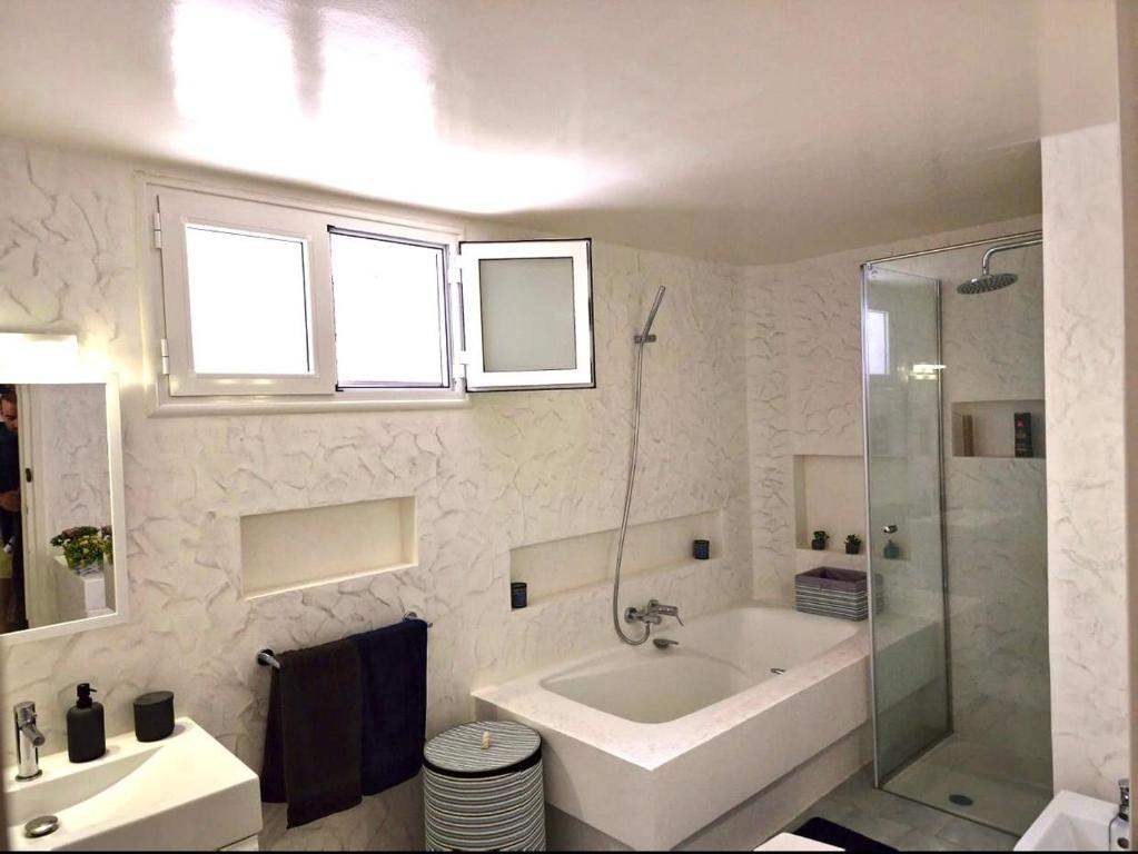 un bagno bianco con vasca e lavandino di Villa de Charme Adultes Only a Nabeul