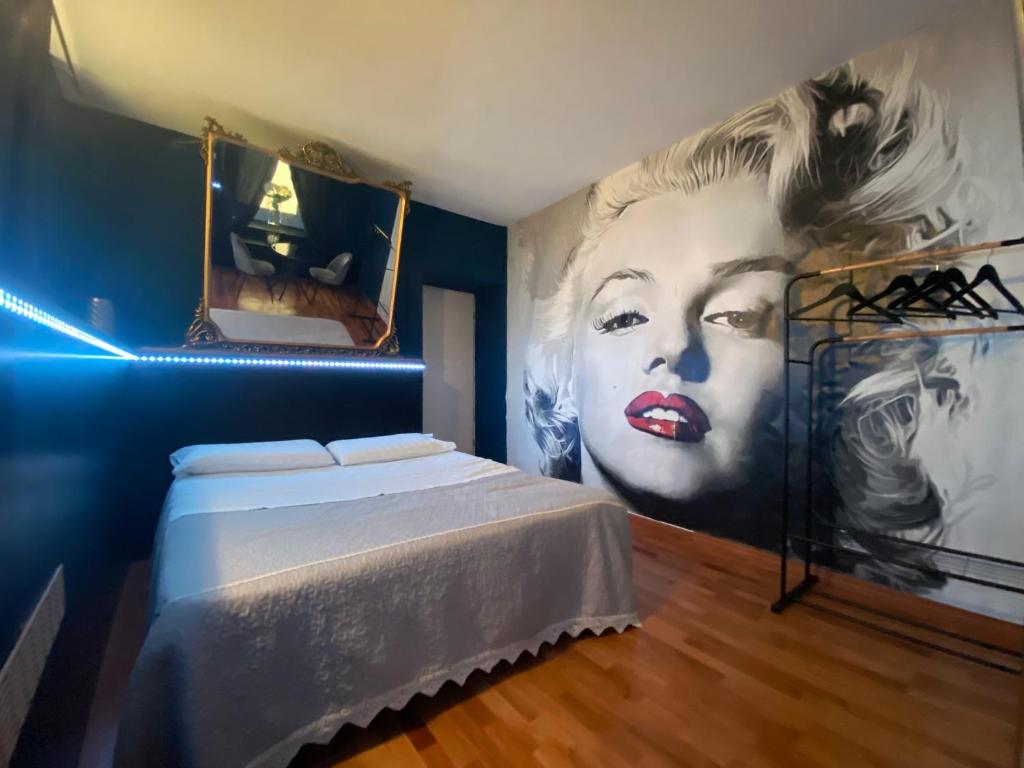 a bedroom with a painting of a woman on the wall at Casa degli Orti, Dolomia best home in Trento