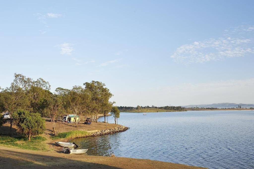 a body of water with two boats on the shore at NRMA Lake Somerset Holiday Park in Kilcoy