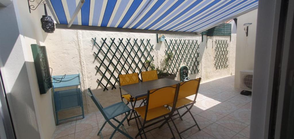 une salle à manger avec une table et des chaises jaunes dans l'établissement Maison de vacances en plein cœur de Châtelaillon-Plage, à Châtelaillon-Plage