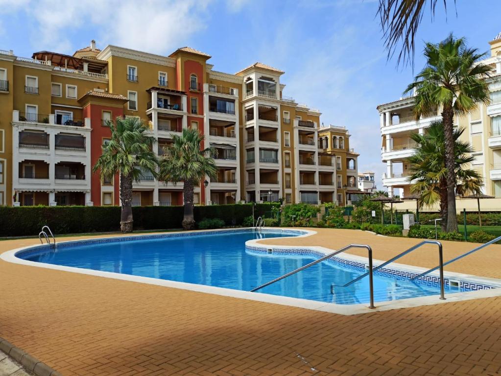 ein Schwimmbad vor einigen Wohnhäusern in der Unterkunft PRECIOSOS APARTAMENTO DE DOS DORMITORIOS in Ayamonte