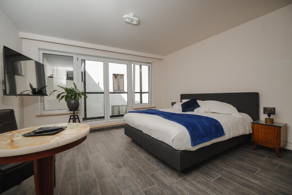 a bedroom with a bed and a table and window at Villa Yvonne in Ostend