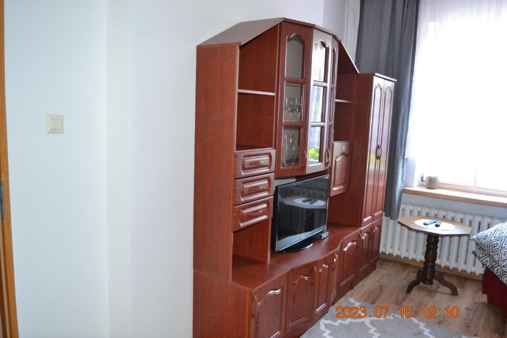 a wooden cabinet with a tv in it at Mieszkanko nad jeziorem in Rosnowo