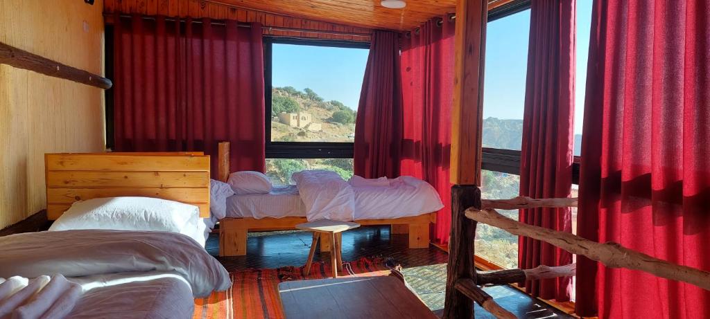 a bedroom with two beds and a large window at Dana Gate Lodge in Dana