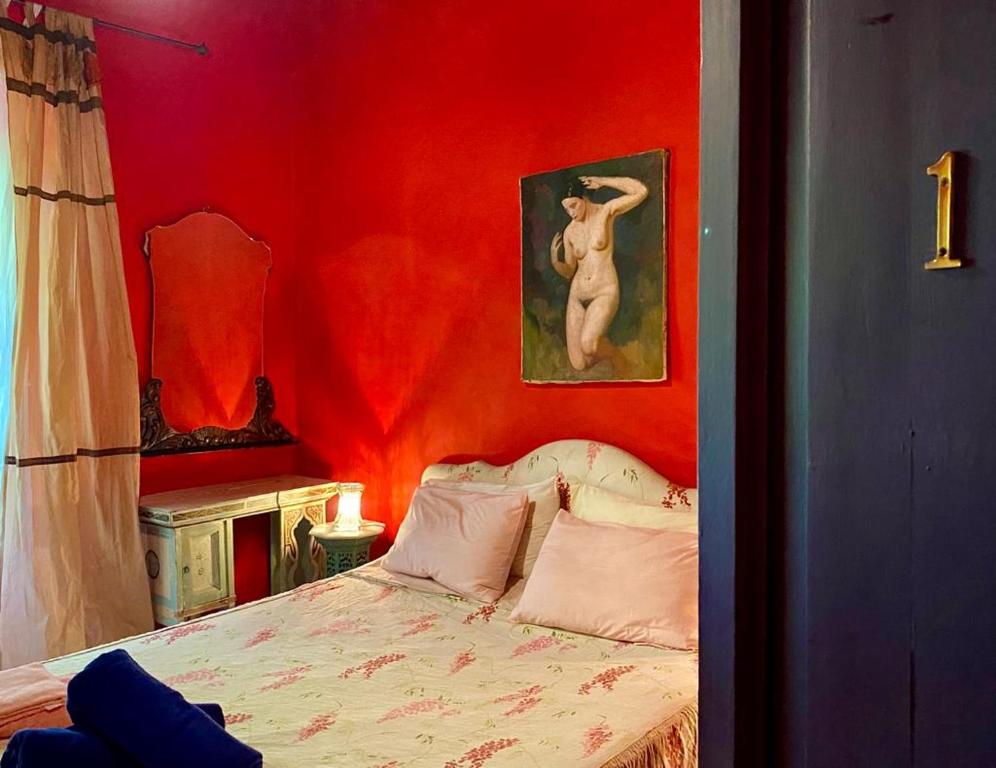 Habitación roja con cama y pintura en la pared en Casa Portale en Ronciglione
