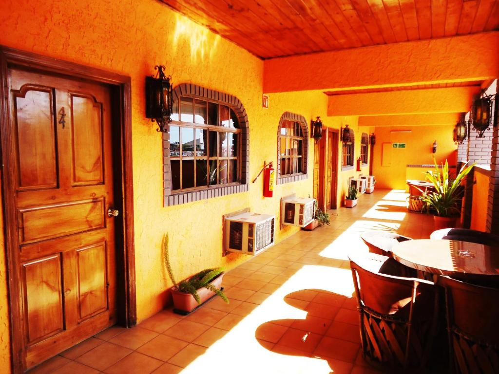 Habitación con puerta, mesa y sillas en Hotel La Hacienda de la Langosta Roja, en San Felipe