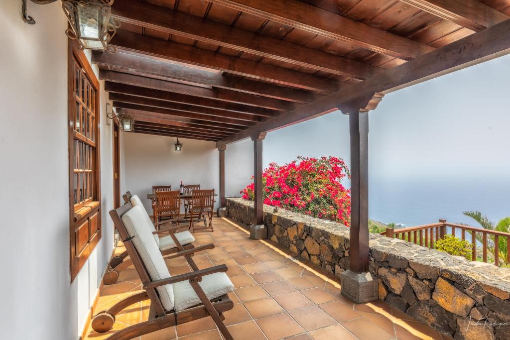 Un balcón con sillas y una pared de piedra. en Lightbooking La Morera Villa de Mazo con piscina en Mazo