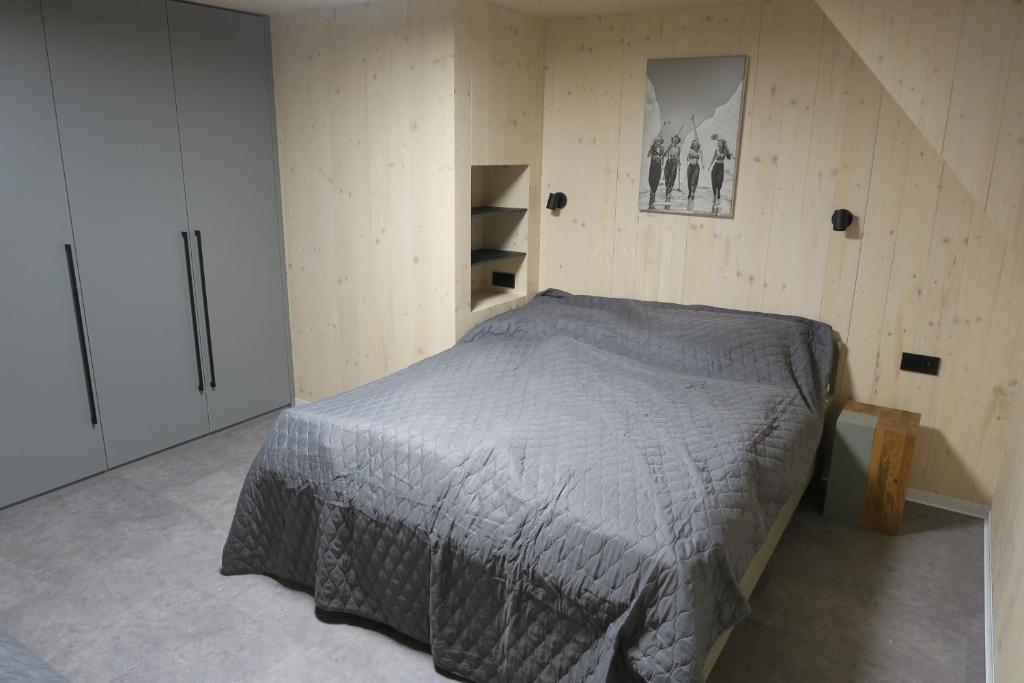 a bedroom with a bed in a wooden wall at Chata Jestřábník in Dolní Morava