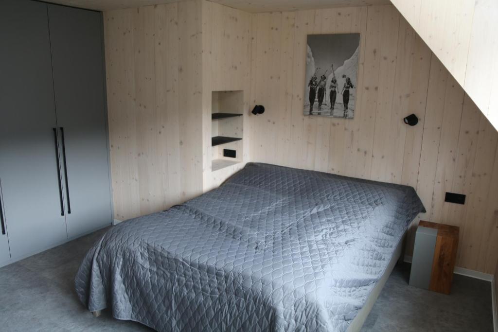 a bedroom with a bed in a wooden wall at Chata Jestřábník in Dolní Morava
