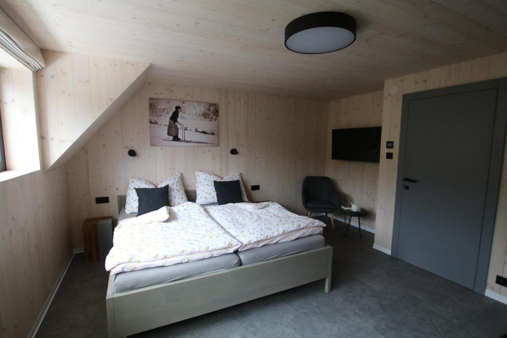 a bedroom with a bed and a staircase at Chata Jestřábník in Dolní Morava