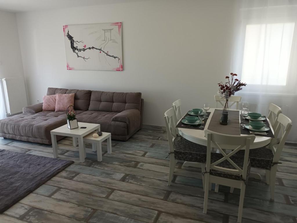 ein Wohnzimmer mit einem Sofa und einem Tisch in der Unterkunft HANDLER Apartman Sopron in Sopron