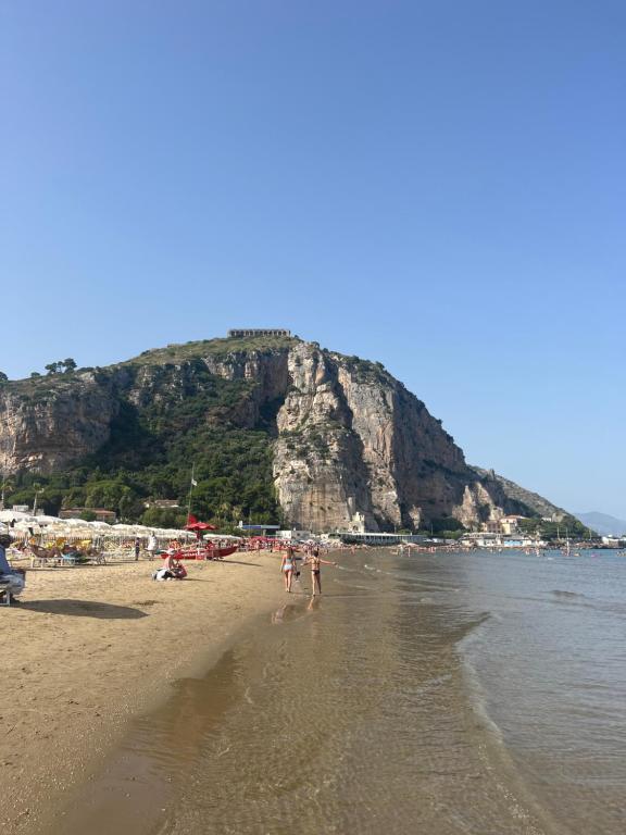 a group of people on a beach with a mountain at Al Vicolo in Terracina