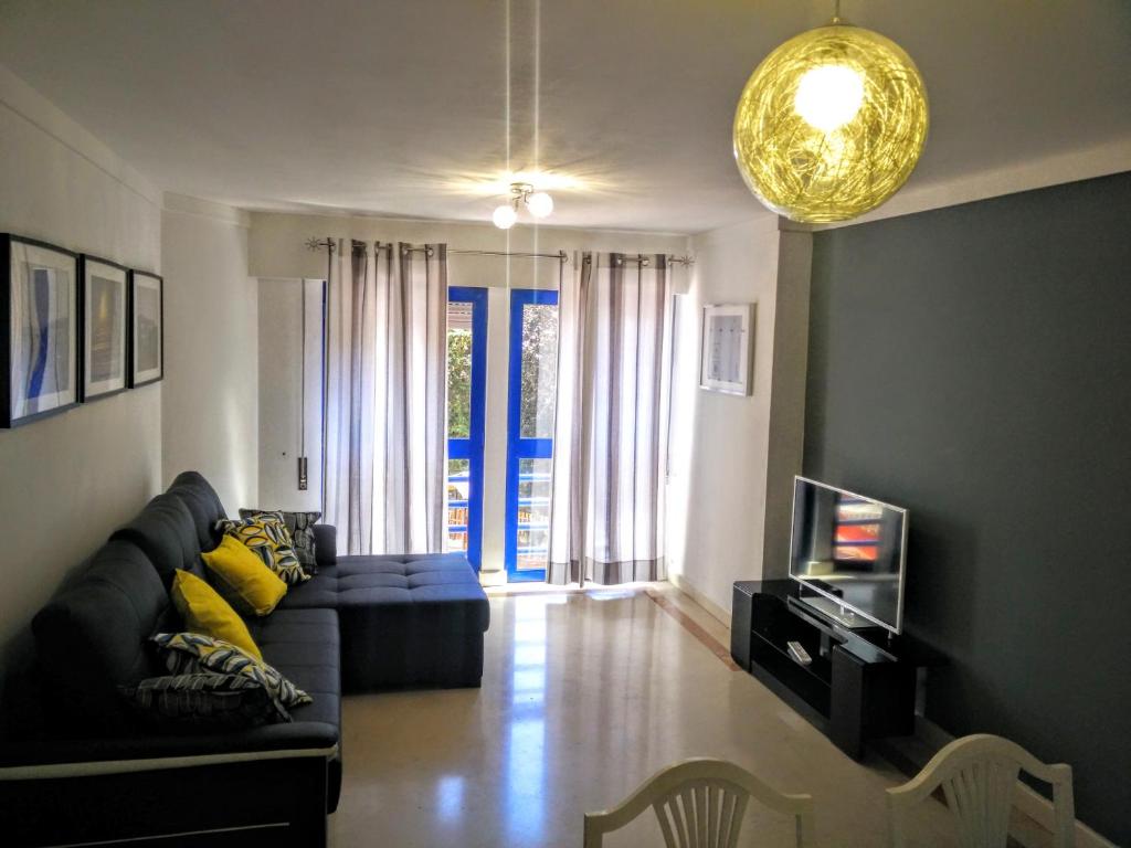 a living room with a couch and a tv at Apartment with private parking next to metro station close to center in Lisbon