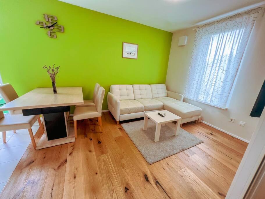 a living room with green walls and a couch and a table at Apartma Nataša in Jagodje